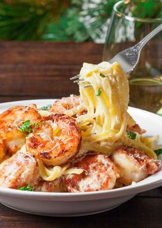 pasta with shrimp and parmesan cheese in a white bowl on a wooden table