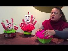 a woman sitting at a table with some candy in her hand and other decorations on the table