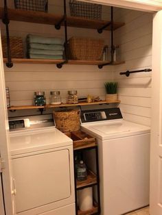 a washer and dryer in a small laundry room with open shelving on the wall