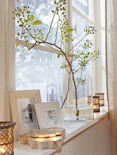 a window sill filled with pictures and candles