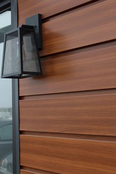 a close up of a light on the side of a building with wood sidings