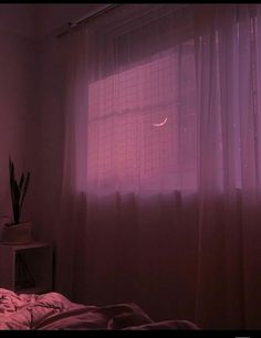 a bedroom with pink light coming from the window and curtains on the windowsill,