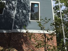 there is a blue house that has a window on the front and side of it