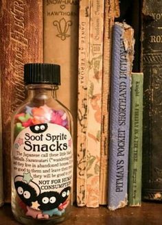 a bottle filled with lots of candy sitting on top of a shelf next to books