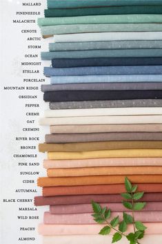 an image of different colors of fabrics and fabric swatches on a white sheet with green leaves