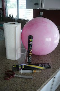 a large pink ball sitting on top of a counter next to a roll of toilet paper