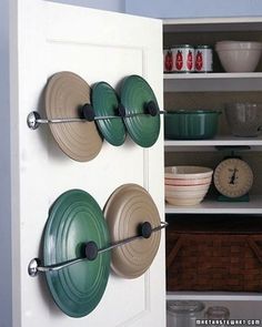 an image of a kitchen cupboard with pots and pans on it's doors