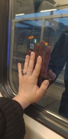 a woman's hand on the window of a train