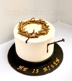 a cake with a crown on top and writing on the side that says, he is risen