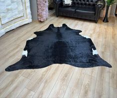 a black and white cowhide rug in a living room