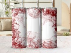 three red and white tumblers sitting on top of a table