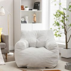 a white bean bag chair sitting on top of a rug in a living room next to a book shelf