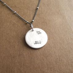 My Small Mother and Baby Duck Necklace is handcrafted in fine silver and features an original design. It has a satin finish and the back is stamped with my dragonfly maker's mark and ".999" to signify fine silver.  Your choice of sterling silver chain is included.S I Z E :  Approx. 5/8" in diameter (16 mm) - a little smaller than a dime.A V A I L A B I L I T Y :  Made-to-order, ships 1-2 weeks after purchase unless otherwise noted above.Because I make each one by hand, yours may vary slightly fr Sterling Silver Stamped Necklace For Birthday Gift, Silver Hand Stamped Necklace For Birthday Gift, Stamped Sterling Silver Jewelry For Birthday, Handmade Sterling Silver Necklace For Birthday, Engraved Silver Necklace For Birthday, Silver Hand Stamped Jewelry For Birthday, Birthday Hand Stamped Silver Jewelry, Silver Stamped Necklace For Birthday, Handmade Silver Jewelry For Birthday