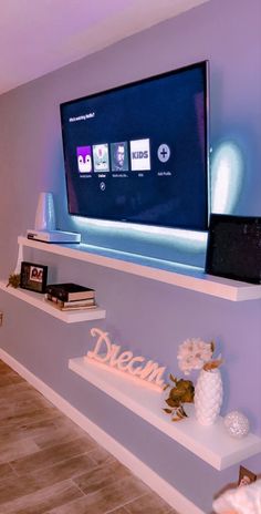 a flat screen tv sitting on top of a white shelf