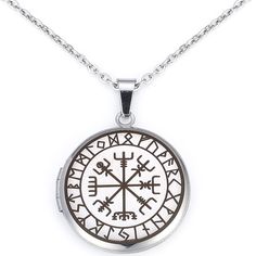 a silver pendant with an image of a compass on it