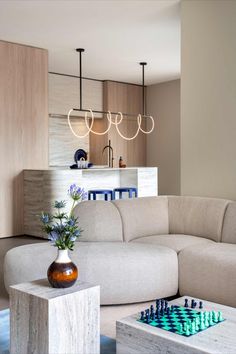 a living room filled with furniture and a chess board on top of a coffee table