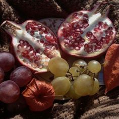 pomegranates, grapes and leaves on a blanket