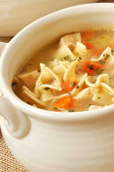 a bowl of chicken noodle soup with crackers