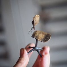 a person holding a tiny piece of metal with a butterfly on it's back