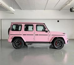 a pink jeep is parked in a garage