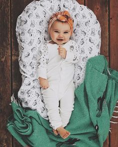 a baby laying on top of a green blanket