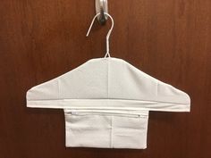 a white jacket hanging from a hook on a wooden door