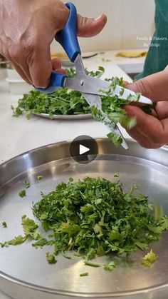 someone cutting up some greens on top of a metal pan