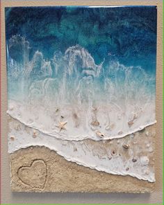 a heart drawn in the sand next to an ocean wave with shells and starfish