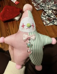 a person holding a stuffed animal on top of a wooden floor next to other items