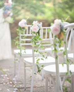 white chairs with flowers and greenery on them are lined up for an outdoor ceremony