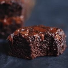 two pieces of chocolate cake sitting next to each other on a black counter top with one piece cut in half