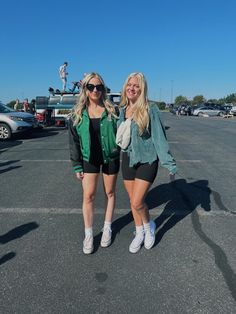 two women standing next to each other in a parking lot