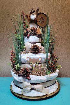 a three tiered cake decorated with pine cones and deer decorations