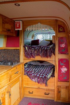 the interior of a small camper with bunk beds and kitchenette in it,