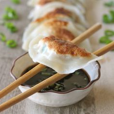 some food is sitting in a bowl with chopsticks sticking out of the top