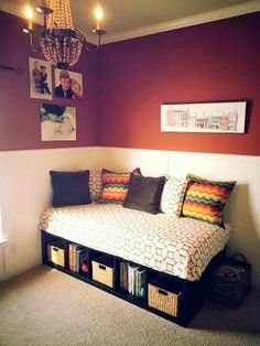 a bedroom with a bed, bookshelf and pictures on the wall above it