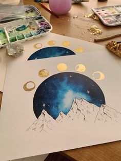 an art project is being done on a table with paint and gold circles around it