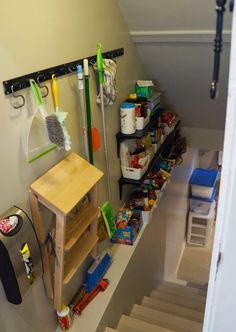 there are many items on the shelves in this room, including brooms and cleaning supplies