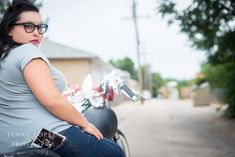 a woman sitting on the back of a motorcycle