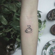 a small coffee cup tattoo on the arm