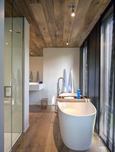 a large white bath tub sitting inside of a bathroom next to a walk in shower