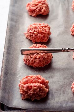 raw hamburger patties are being prepared on a baking sheet