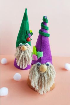 two purple and green gnome hats sitting on top of a table