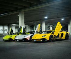 three yellow and white sports cars parked next to each other in an empty parking garage