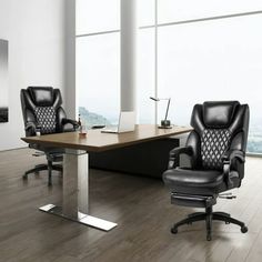 two black leather office chairs sitting in front of a wooden desk and chair on top of a hard wood floor