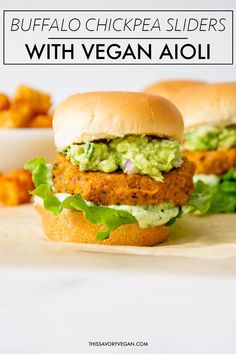 two chicken sliders with guacamole and lettuce on the side