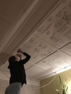 a woman standing in front of a ceiling with writing on it