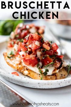 a white plate topped with bruschetta chicken covered in tomatoes and onions next to a fork