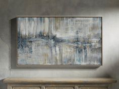 an abstract painting hangs on the wall next to a dresser in a room with gray walls