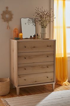 a bedroom with a dresser, mirror and yellow curtains